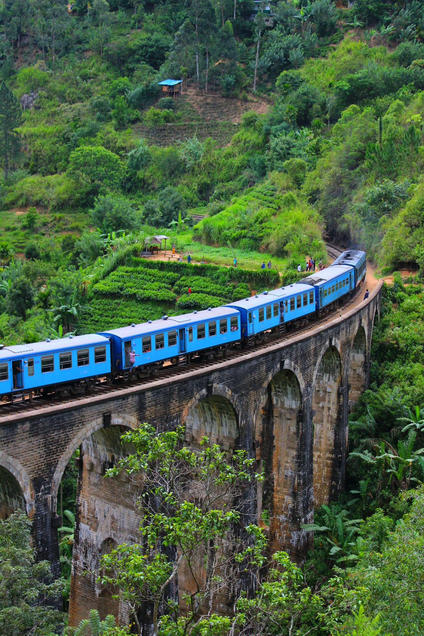 Blue train crossing the Nine Arch Bridge near Ella
